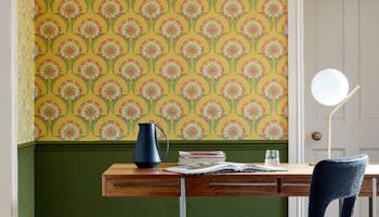 Yellow patterned wallpaper with green paint below the dado rail